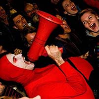 Red Bastard, bouffon-clown, liberates the energy of a crowd with a megaphone